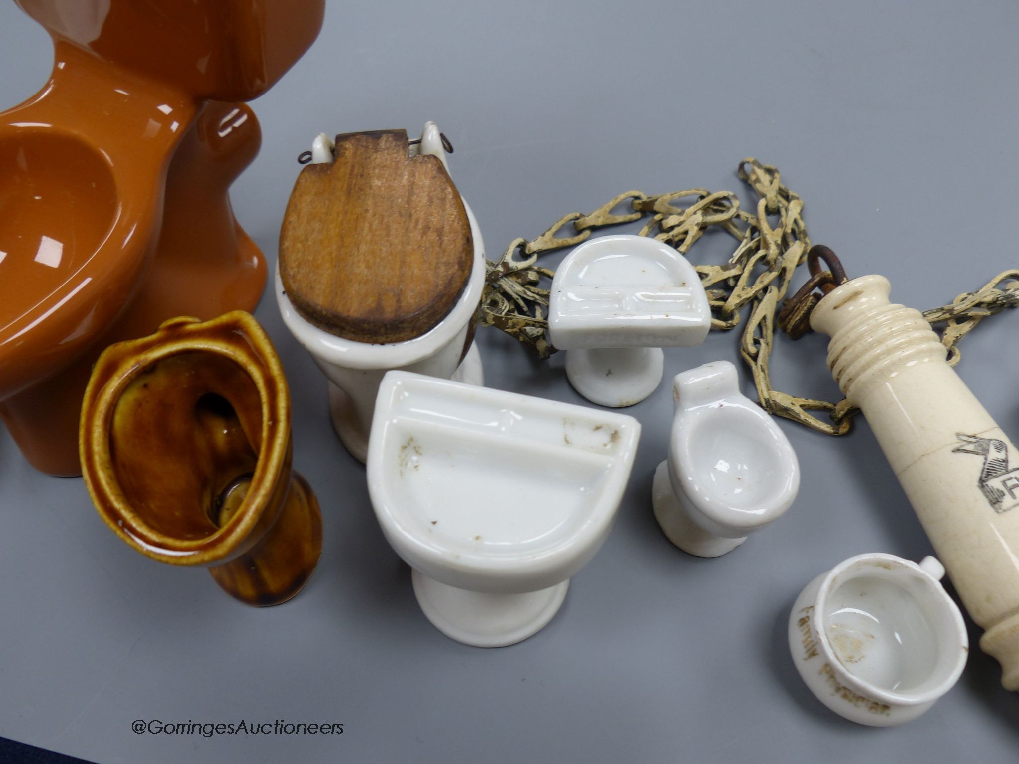 A group of various miniature models of toilets and a pull chain